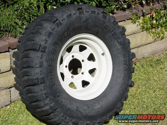 Off-road tire with 'Super Swamper Bogger' text on a white rim