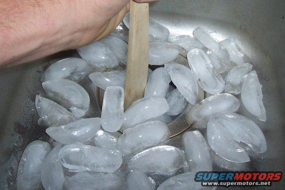 hand stirring ice in a sink
