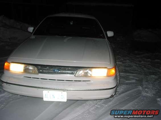 1995 Ford Crown Victoria front end with headlights on, parked in snow. License plate reads ALLN 26