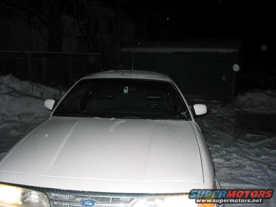 Front view of a white 1996 Ford Crown Victoria parked in the snow at night