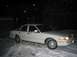 1996 Ford Crown Victoria - A white sedan sits in the snow at night, with a house in the background.