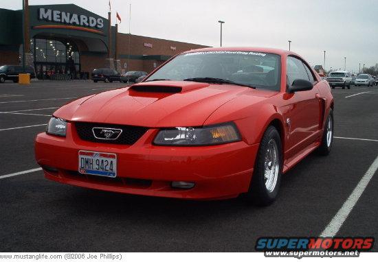 Red 2004 Ford Mustang coupe with a hood scoop, parked in a lot