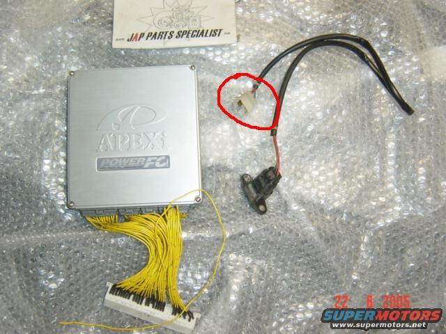 Silver APEXi Power FC ECU with yellow wiring harness and a separate sensor with black wires