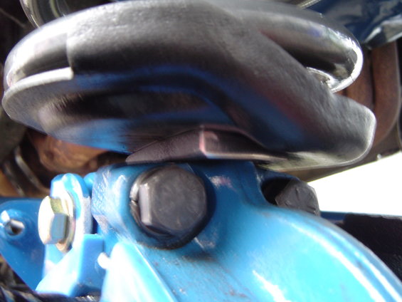 Blue suspension component with black bolts and a silver spacer