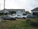 1965 Ford Mustang - Three classic Ford Mustangs are parked in a residential driveway.
