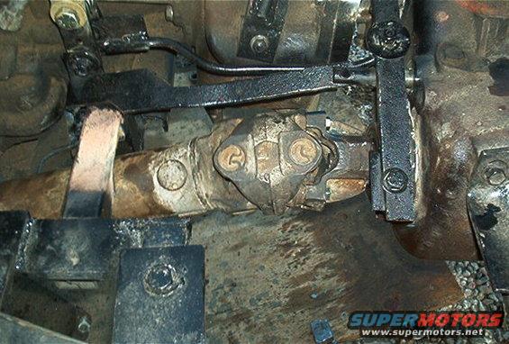 Driveshaft U-joint with grease and rust, viewed from below