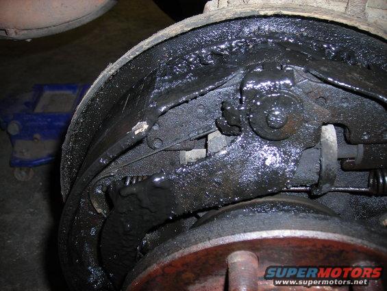 Greasy brake drum and shoes with visible wear and tear