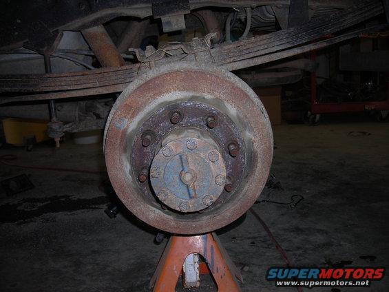 Rear axle hub and brake drum on jack stands, showing leaf springs above