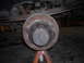 1995 Ford F-250 - Close-up view of a rusty rear axle hub and brake drum assembly supported by orange jack stands.