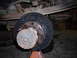 1995 Ford F-250 - Close-up of a vehicle's rear axle hub and brake drum assembly, supported by a jack stand.