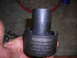 1995 Ford F-250 - A Powerbuilt spindle nut tool is held in a hand against a concrete background.