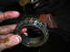 1995 Ford F-250 - A mechanic holds a greasy wheel bearing, with oil dripping from the vehicle's axle assembly.