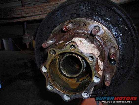 Close-up of a rusty truck wheel hub with brake drum and lug studs
