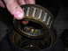 1995 Ford F-250 - A mechanic inspects a used wheel bearing, likely for a Ford F-250.