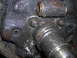 1995 Ford F-250 - Close-up view of a heavily greased axle housing and spindle, showing bolts and bearing surfaces.
