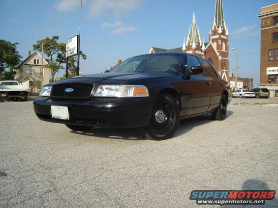 Black 2000 Ford Crown Victoria parked on asphalt with a church in the background