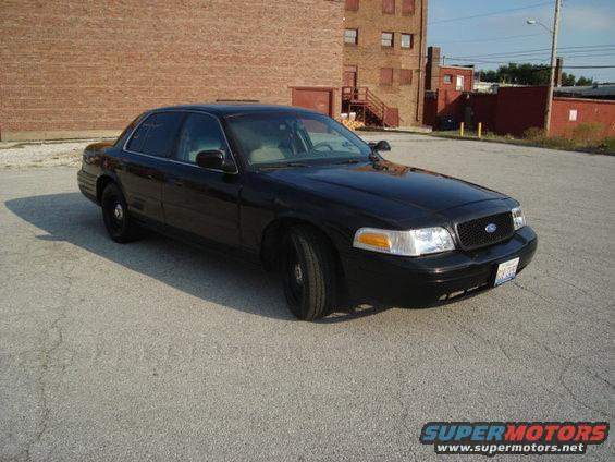 Black 2000 Ford Crown Victoria sedan, front 3/4 view, parked on asphalt lot