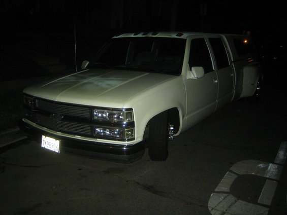 White dually pickup truck with a camper shell. License plate reads TK98906