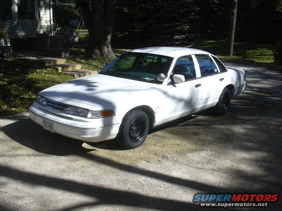 1997 Ford Crown Victoria, white, black steel wheels, parked on driveway