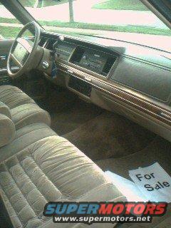 Tan velour interior of a 1980s sedan, showing dashboard, steering wheel, and seats