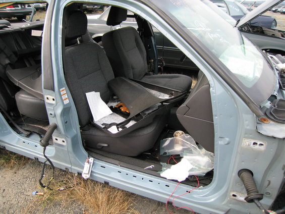 Interior of a light blue car with torn seats and exposed wires