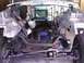 1978 Ford Bronco - The front end of a vehicle is disassembled, revealing the chassis and engine bay.