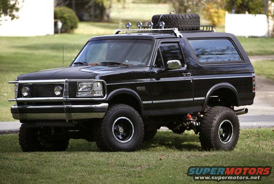 Black 1995 Ford Bronco with roof rack, spare tire, and bull bar