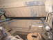 1989 Ford Bronco - Underside view of a vehicle's rear axle and driveshaft, with visible blue lines and silver shock absorbers.