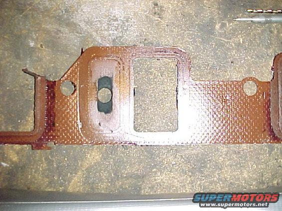 mvc026f.jpg 1968 Ford 428CJ intake gasket. The 428 CJ did not have a heat riser valve like previous engines, so the intake gasket has a restrictor on the driver's side. This is a picture of an original gasket showing the 5/8" hole. The passenger side is wide open and the gasket on that side is a different part number.
 