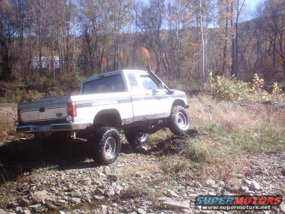 1990 Ford Ranger with snorkel and lift kit driving on rocky terrain