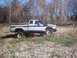 1990 Ford Ranger - A lifted pickup truck with a snorkel is parked on a rocky, dry creek bed with trees in the background.
