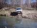 1990 Ford Ranger - A gray Ford Ranger is parked on a rocky bank next to a body of water.