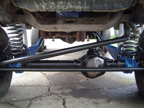 Undercarriage of a lifted vehicle showing suspension components and differential
