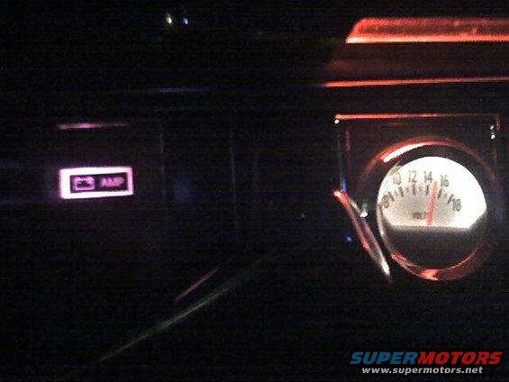 Dashboard interior with a lit amp indicator and a voltage gauge showing approximately 14 volts