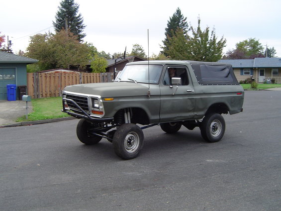 Lifted 1978 Ford Bronco with a brush guard and soft top, parked on a suburban street