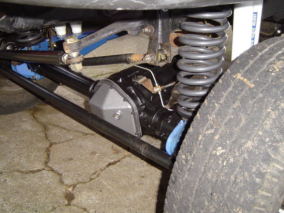 Close-up of front axle, differential cover, and coil spring