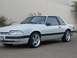 1991 Ford Mustang - White 1991 Ford Mustang coupe parked outdoors with a light-colored wall in the background.