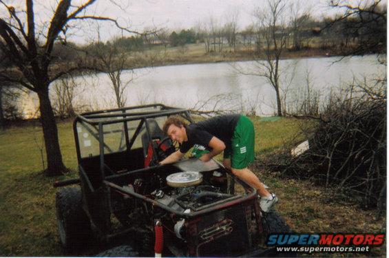Off-road buggy engine bay with a person leaning in to work on it