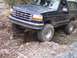 1995 Ford Bronco - A 1995 Ford Bronco tackles a challenging off-road obstacle with its front tire dropping into a crevice.