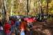 1992 Jeep Cherokee - A group of Jeeps are gathered in a forest during the fall season, with colorful leaves on the trees.