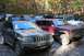 1992 Jeep Cherokee - A group of Jeep Cherokees and other SUVs are parked in a forest clearing with fall foliage.