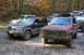 1992 Jeep Cherokee - Multiple Jeep SUVs are parked on a dirt path in a wooded area during autumn.