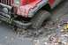 1992 Jeep Cherokee - A red Jeep Cherokee is stuck in thick mud, with its front tire deep in the mire.