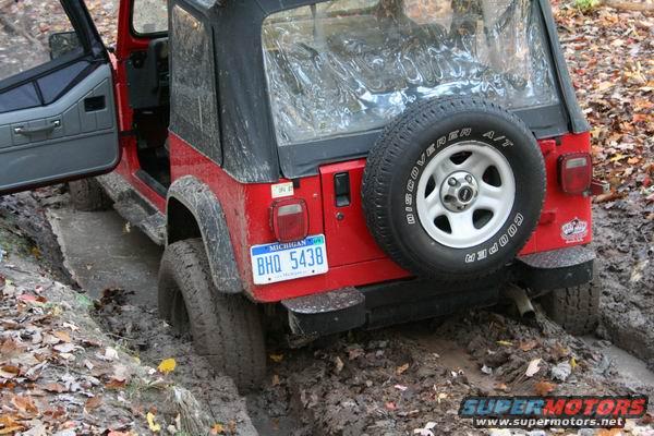 Red Jeep Wrangler stuck in mud, rear view, Michigan license plate BHQ 5438