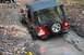 1992 Jeep Cherokee - A red Jeep Wrangler is stuck in a muddy off-road trail, with a driver looking out the window.
