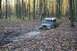 1992 Jeep Cherokee - Jeep CJ-7 navigating a muddy trail through a forest during autumn.
