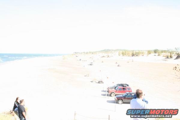 Red 1992 Jeep Cherokee parked on sand near beach