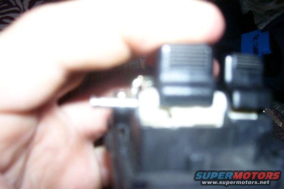Close-up of black car interior knobs with a hand in frame. Supermotors.net logo visible