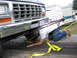 1979 Ford F-150 - A person secures a 1979 Ford F-150 to a trailer, with RVs visible in the background.