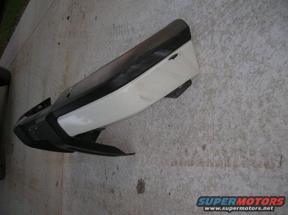 car bumper with black and white sections, lying on concrete